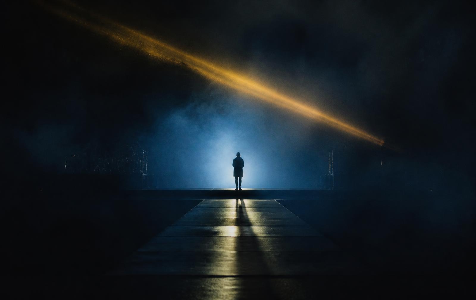 Cinematic stage lit in blue haze with a gold light beam